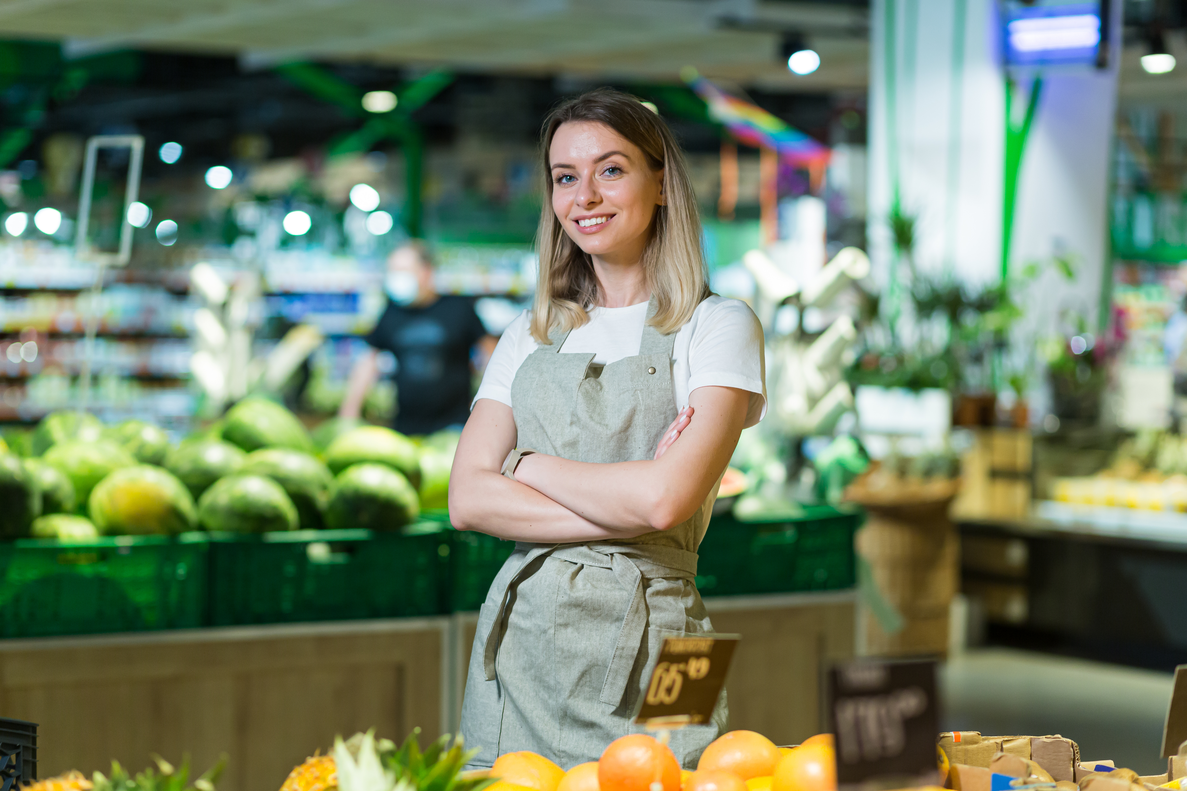 Retail store associate smiling in produce aisle
